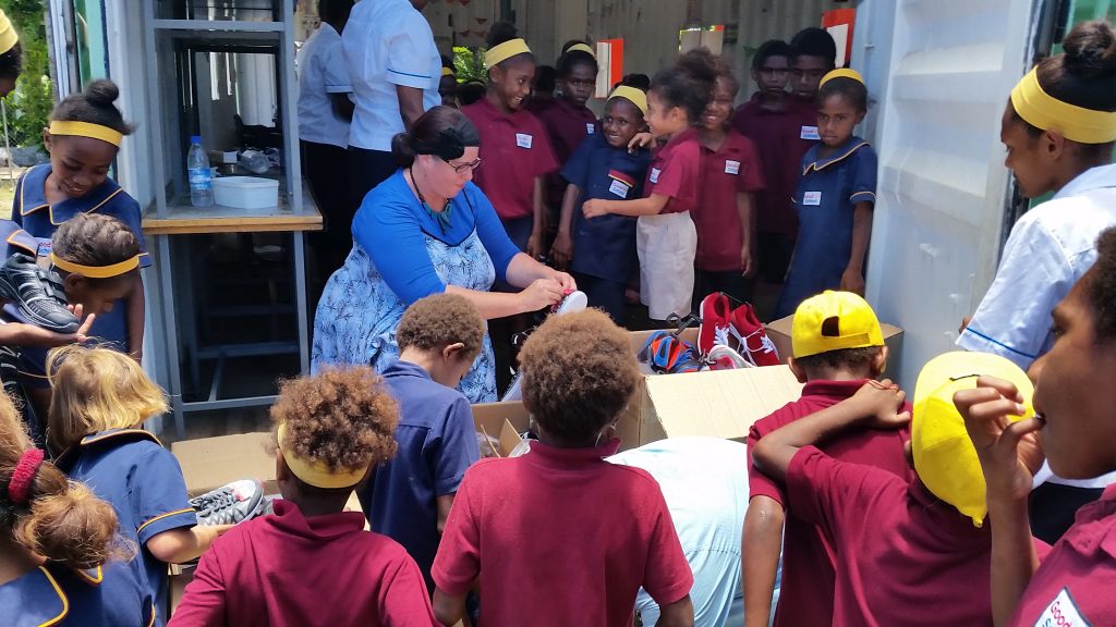 Those helping children try on new shoes at a school in Vanuatu. 